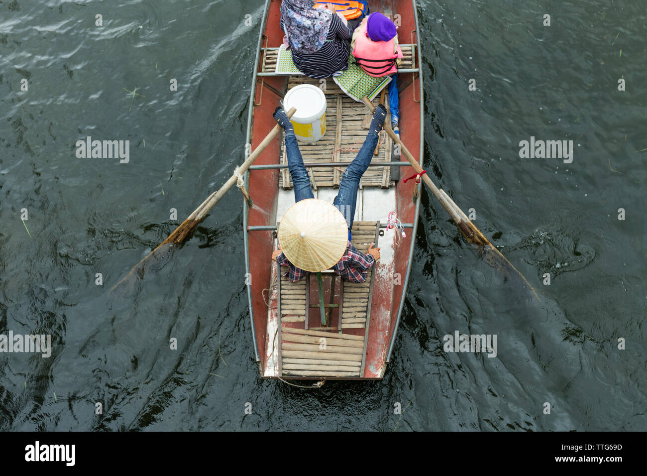 Donna vietnamita paddling barca con gambe Foto Stock