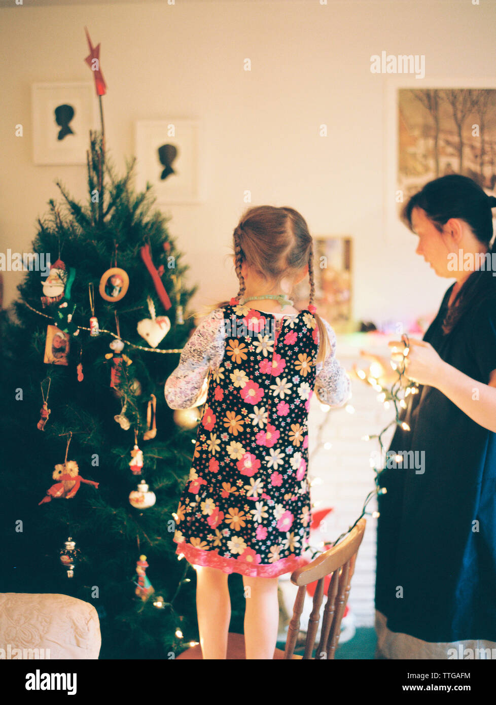 La madre e sua figlia decorano l'albero di natale Foto Stock