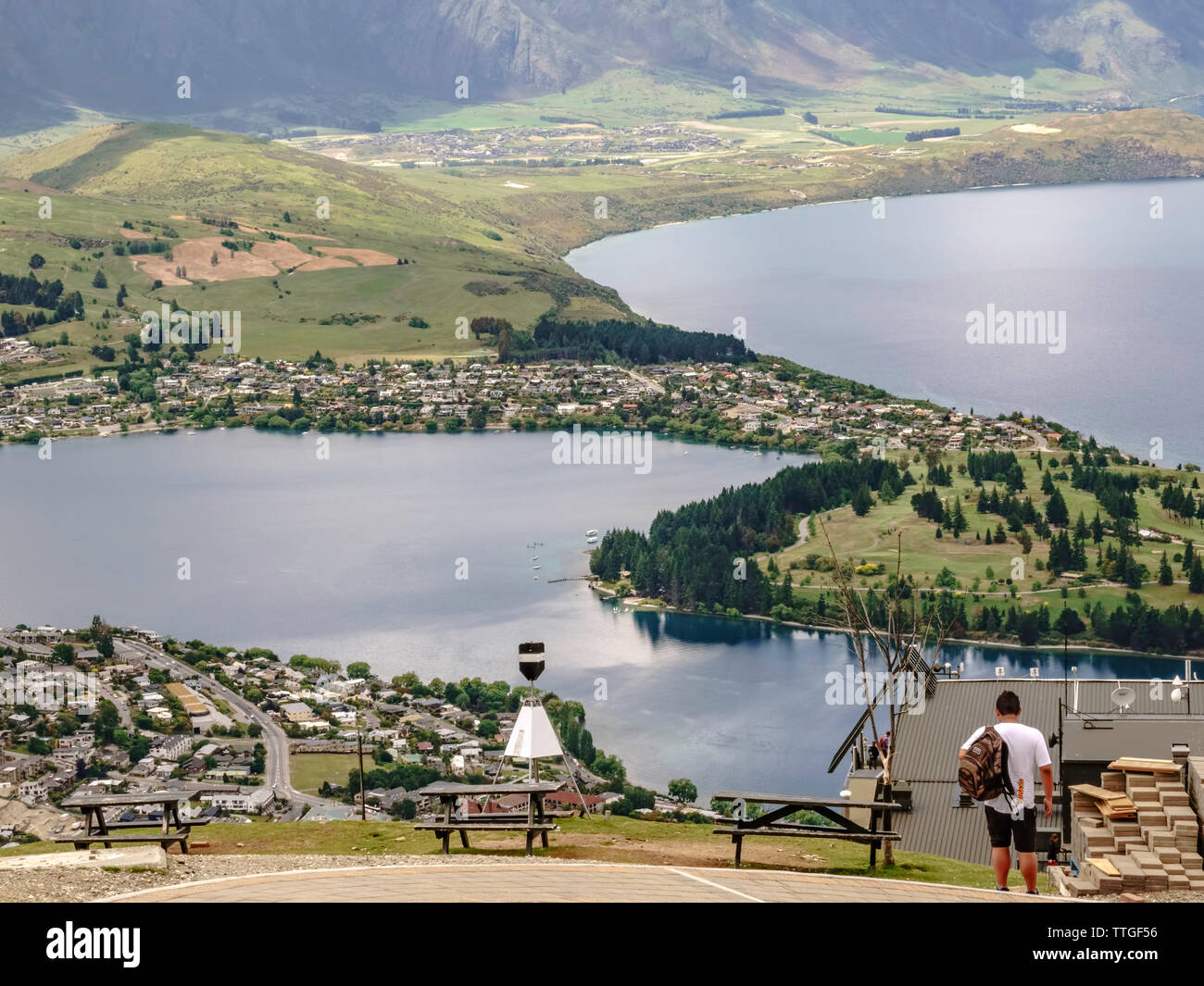 Giovane uomo sulla montagna porta nelle viste sopra Queenstown, Nuova Zelanda Foto Stock