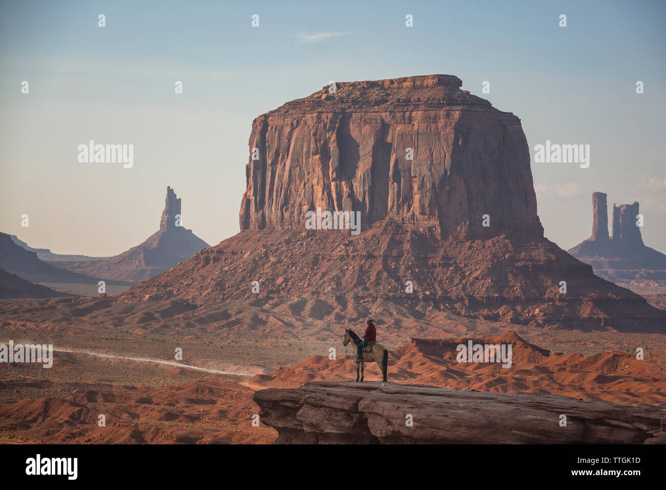 Uomo a cavallo su roccia nella Monument Valley Foto Stock