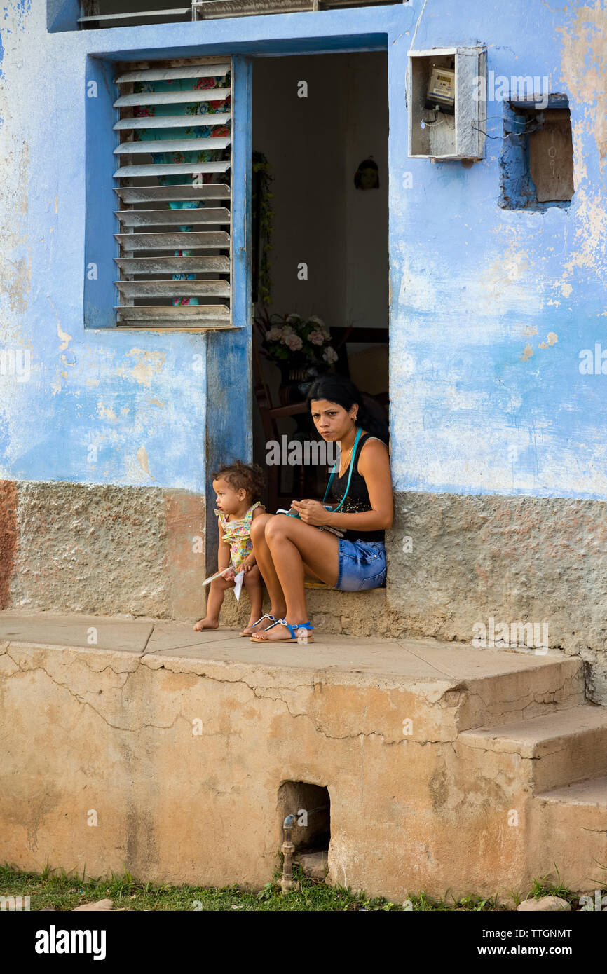 Madre e figlia seduto fuori casa. Trinidad, Cuba. 2017. Foto Stock