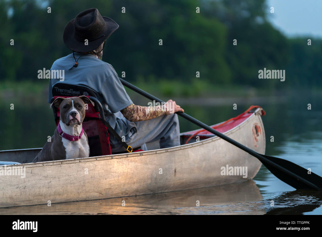 L uomo e il suo cane in una canoa, Lincoln Park, fiume Milwaukee, Wisconsin Foto Stock