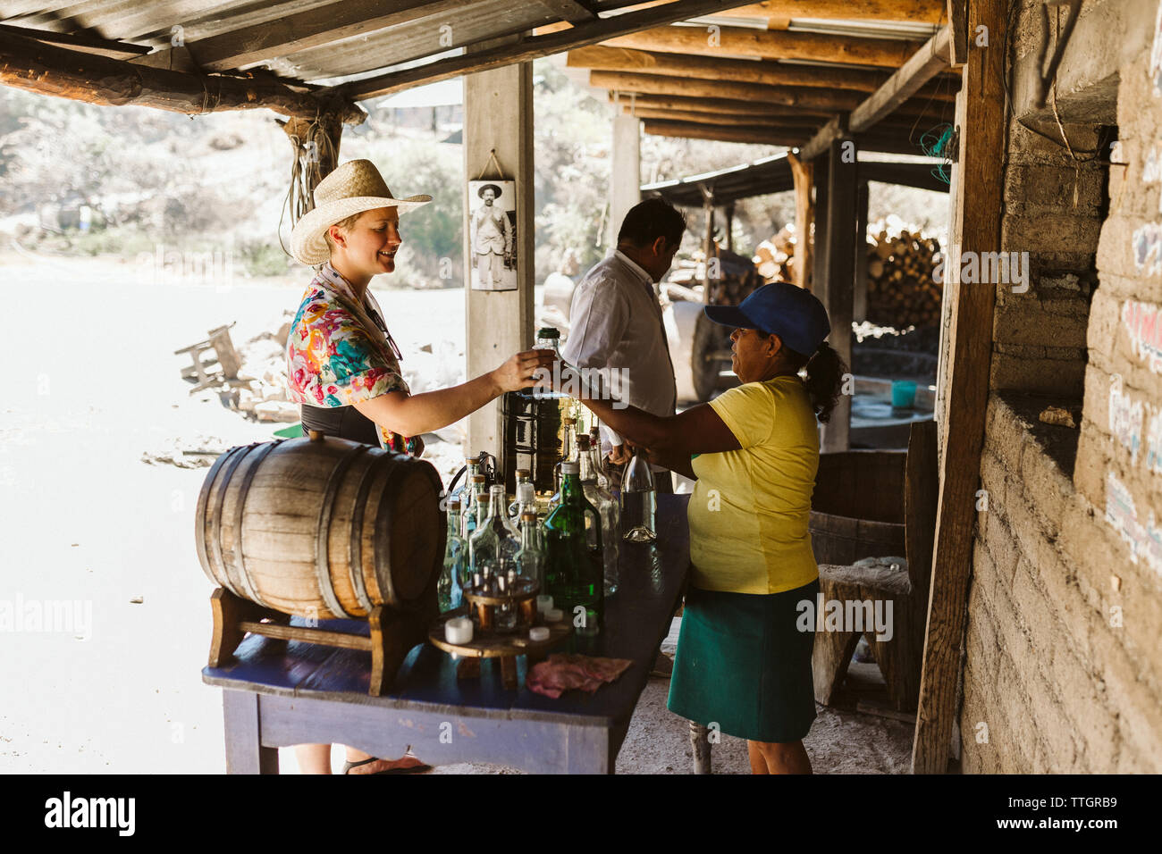 I gusti turistici mezcal presso una distilleria di strada in Messico Oaxaca Foto Stock