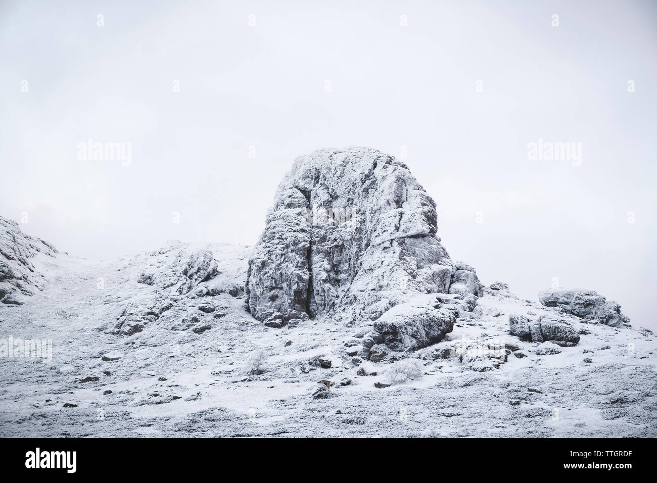 Coperta di neve rocce contro il cielo chiaro Foto Stock