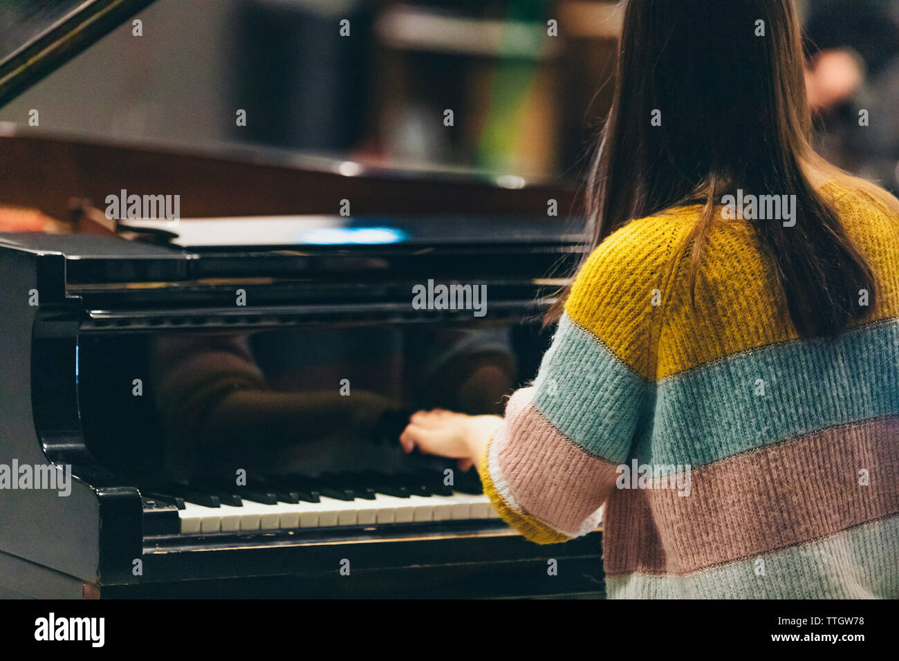 La testa e le spalle della donna che gioca sul pianoforte nella sala da  concerto Foto stock - Alamy