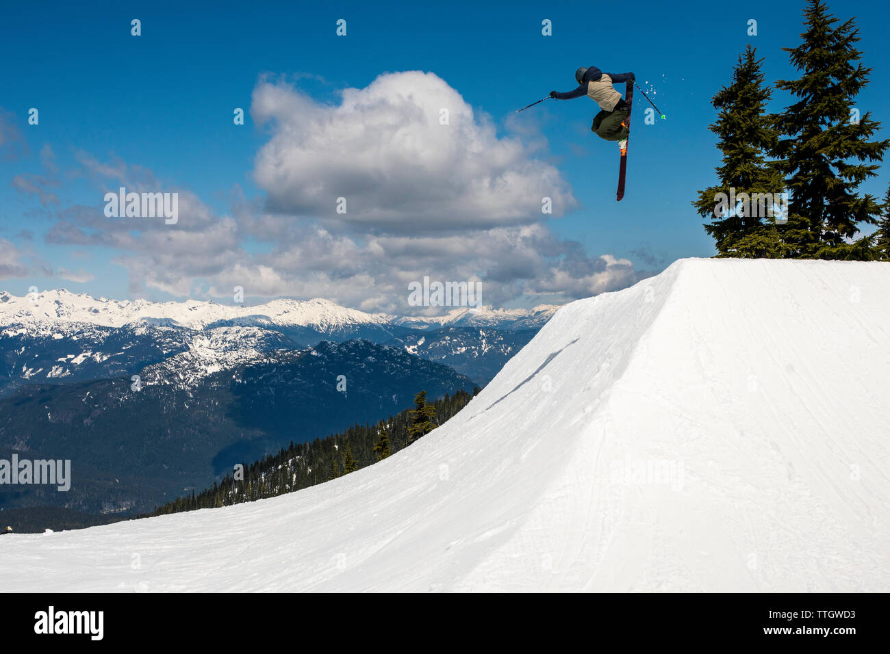 Un uomo colpisce un salto con gli sci nel parco del terreno a Whistler Blackcomb. Foto Stock