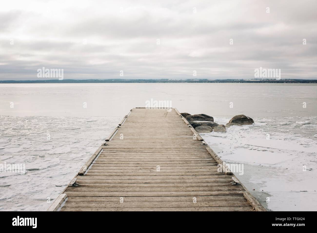 Lungo il molo e rocce presso il lago in Canada con il cielo nuvoloso Foto Stock