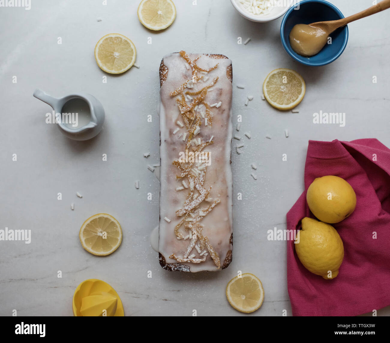 Torta al limone con limoni e gli ingredienti intorno la torta Foto Stock