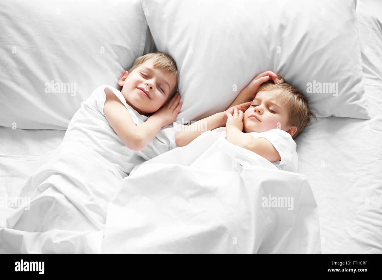 Simpatici ragazzi dormire nel letto sotto coperta, primo piano Foto stock -  Alamy