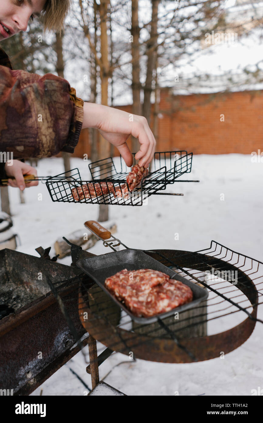 L'uomo le patatine fritte cotolette di hamburger. barbecue grill Foto Stock