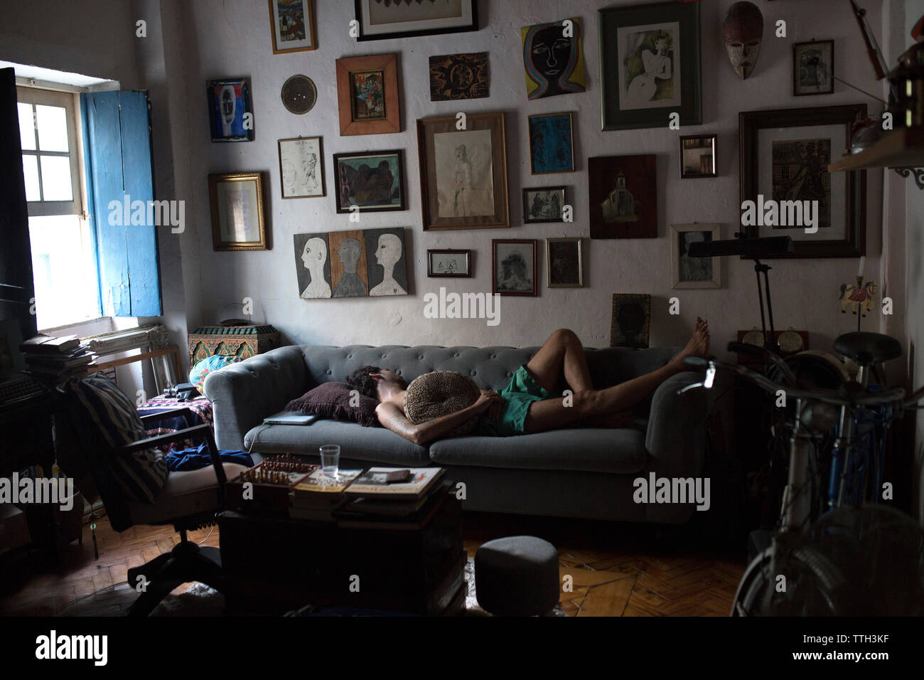 Uomo di dormire su un divano in casa artistica Foto Stock