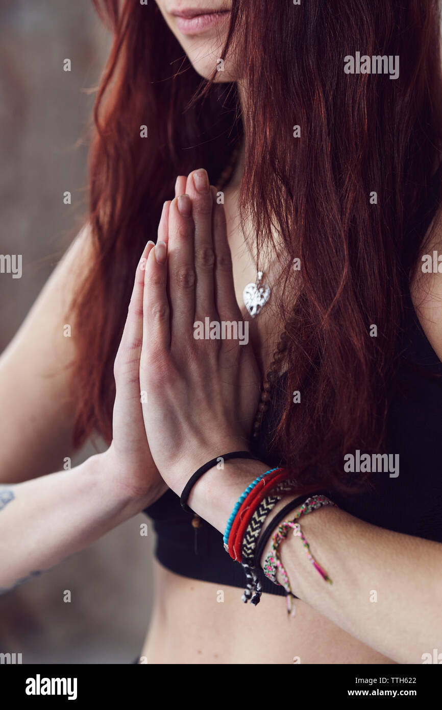 Close up di mani femminili in posa yoga dal muro di mattoni Foto Stock