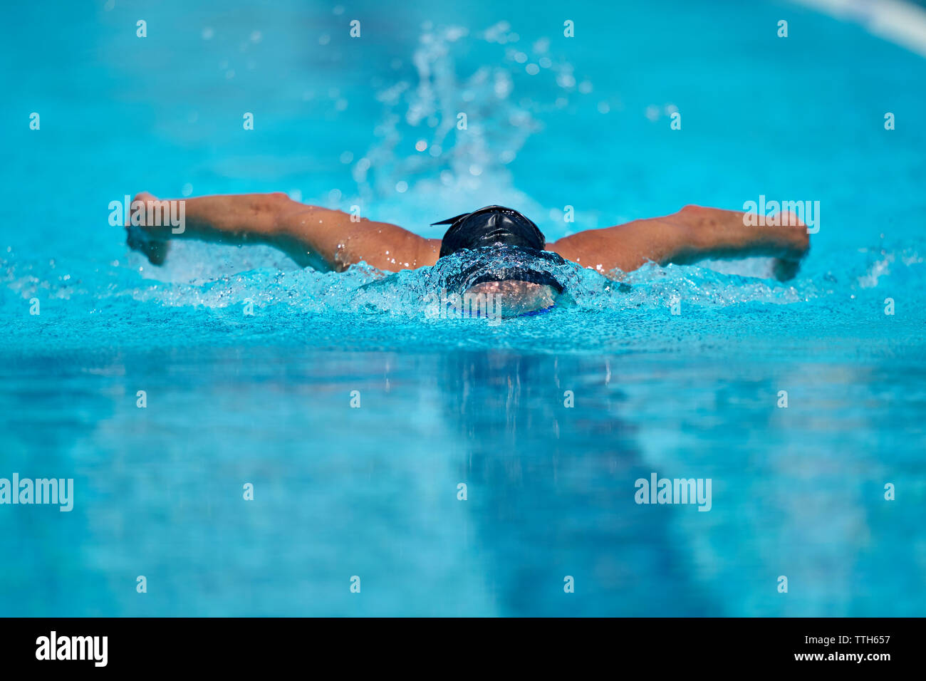 Chiusura del nuotatore facendo corsa a farfalla in piscina Foto Stock