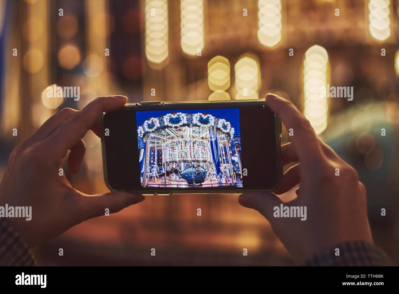 Donna prendendo immagini dello smartphone di Merry Go Round, Spagna Foto Stock