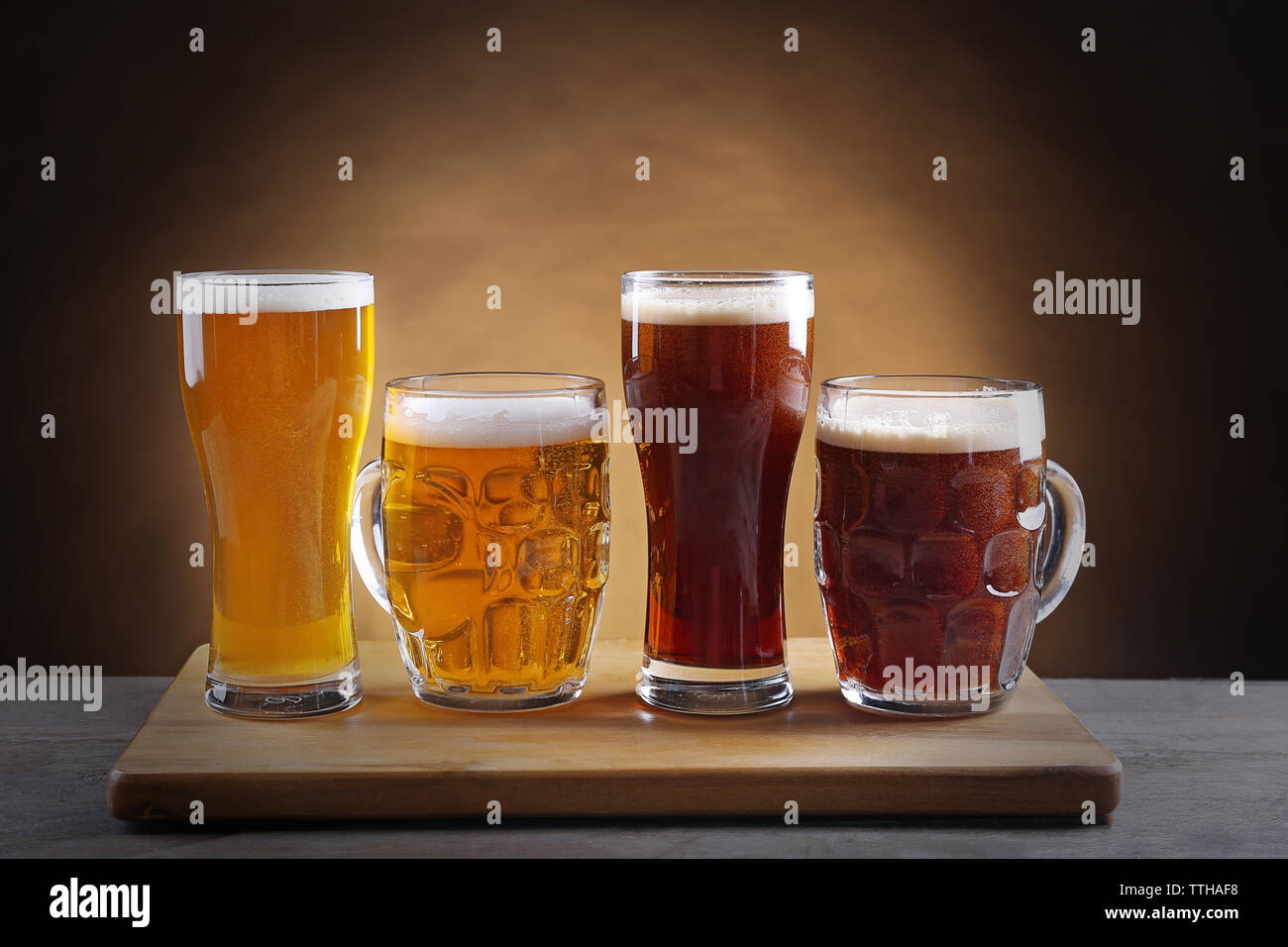 Diversi tipi di birra alla spina in bicchieri sul tavolo di legno Foto Stock