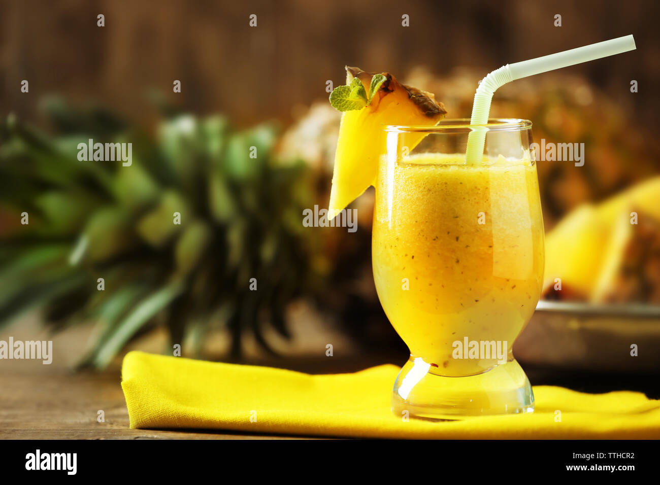 Frullato di ananas nel bicchiere da cocktail su sfondo di legno Foto Stock