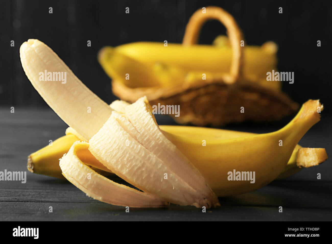 Mezza banana pelata su scuro dello sfondo in legno Foto Stock