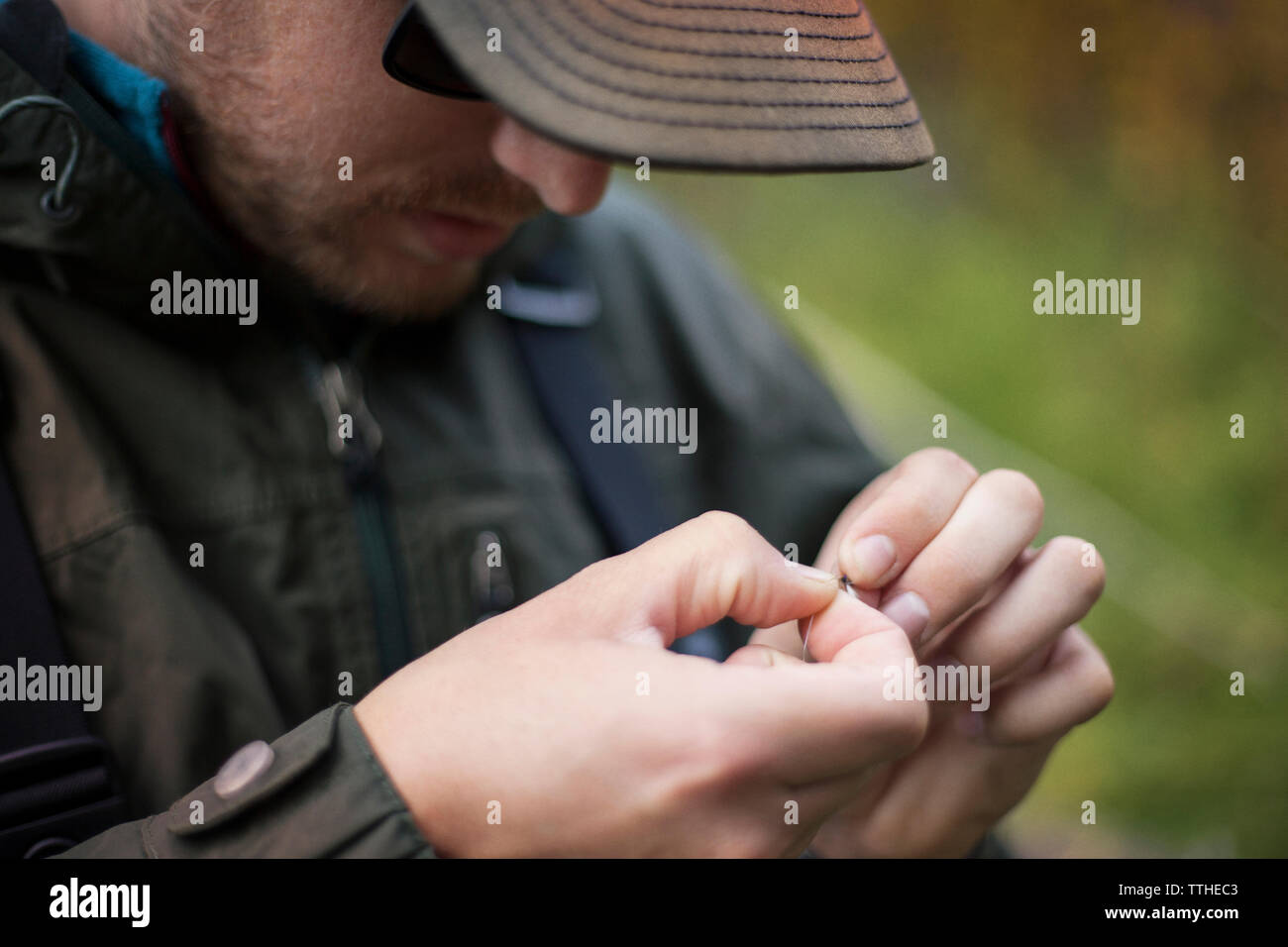 Immagine ritagliata di un escursionista la preparazione di esche da pesca Foto Stock