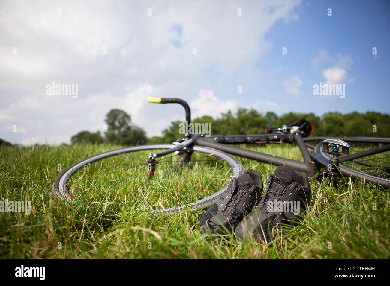 Bicicletta e calzature sportive sul campo erboso contro sky Foto Stock