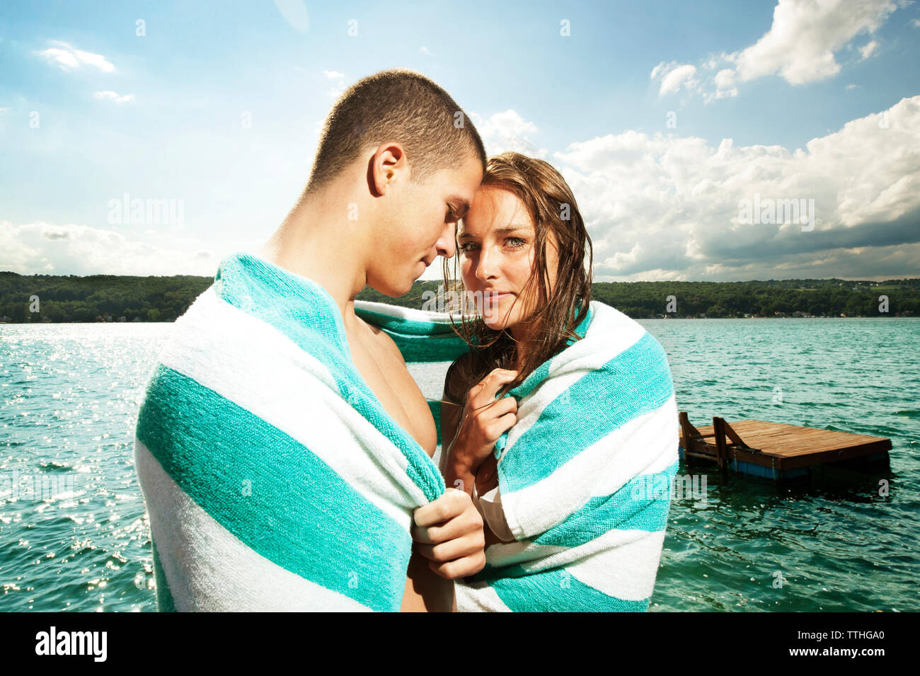 Coppia romantica avvolto in asciugamano contro il lago Foto Stock