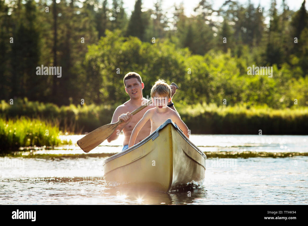 Padre sorridente in barca con il figlio sul lago Foto Stock