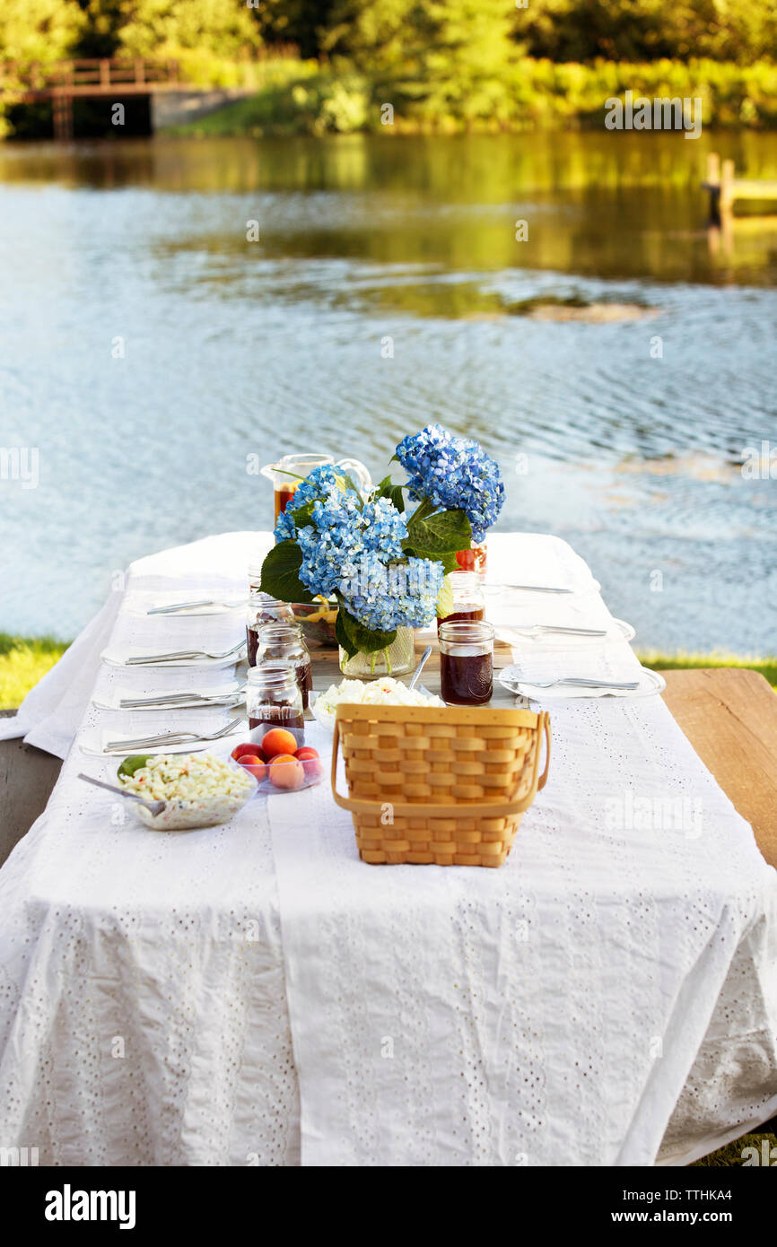 Angolo di Alta Vista del tavolo da picnic contro il fiume Foto Stock