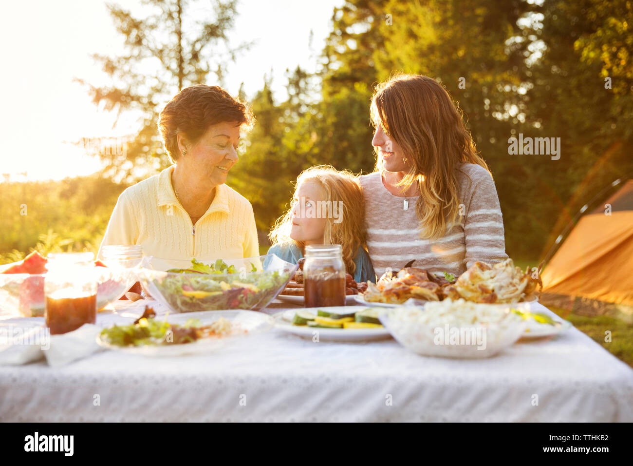 Multi generazione godendo di famiglia sul tavolo da picnic Foto Stock