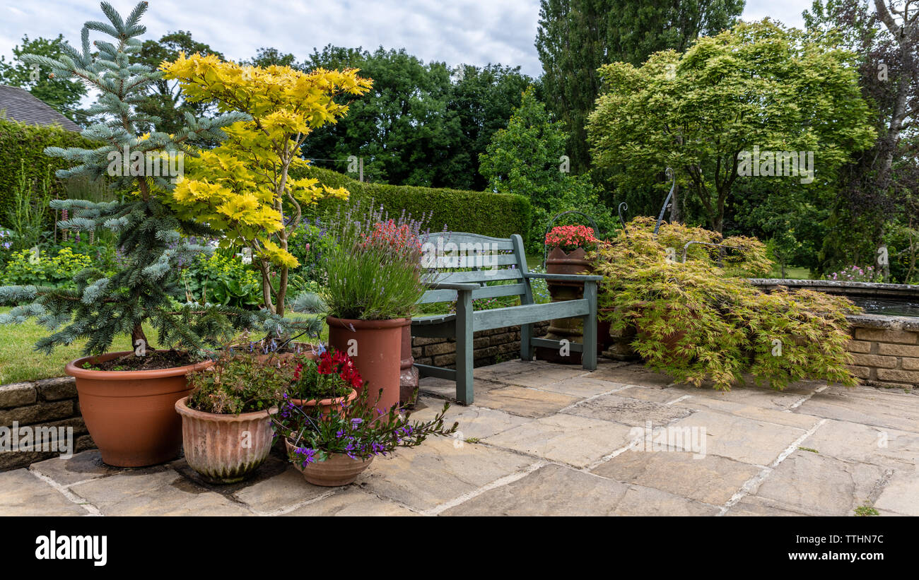 Vasi per piante e sedile, English Country Garden, Gloucestershire, Regno Unito Foto Stock
