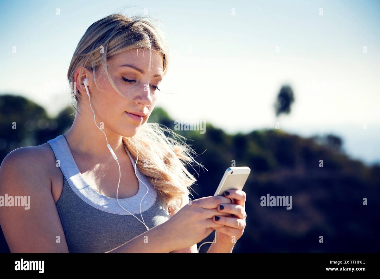 Donna che mantiene il cellulare mentre ascolti la musica Foto Stock