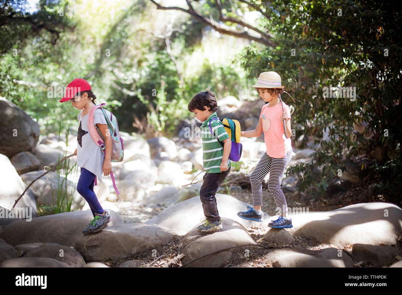 Bambini passeggiate su roccia nella foresta Foto Stock