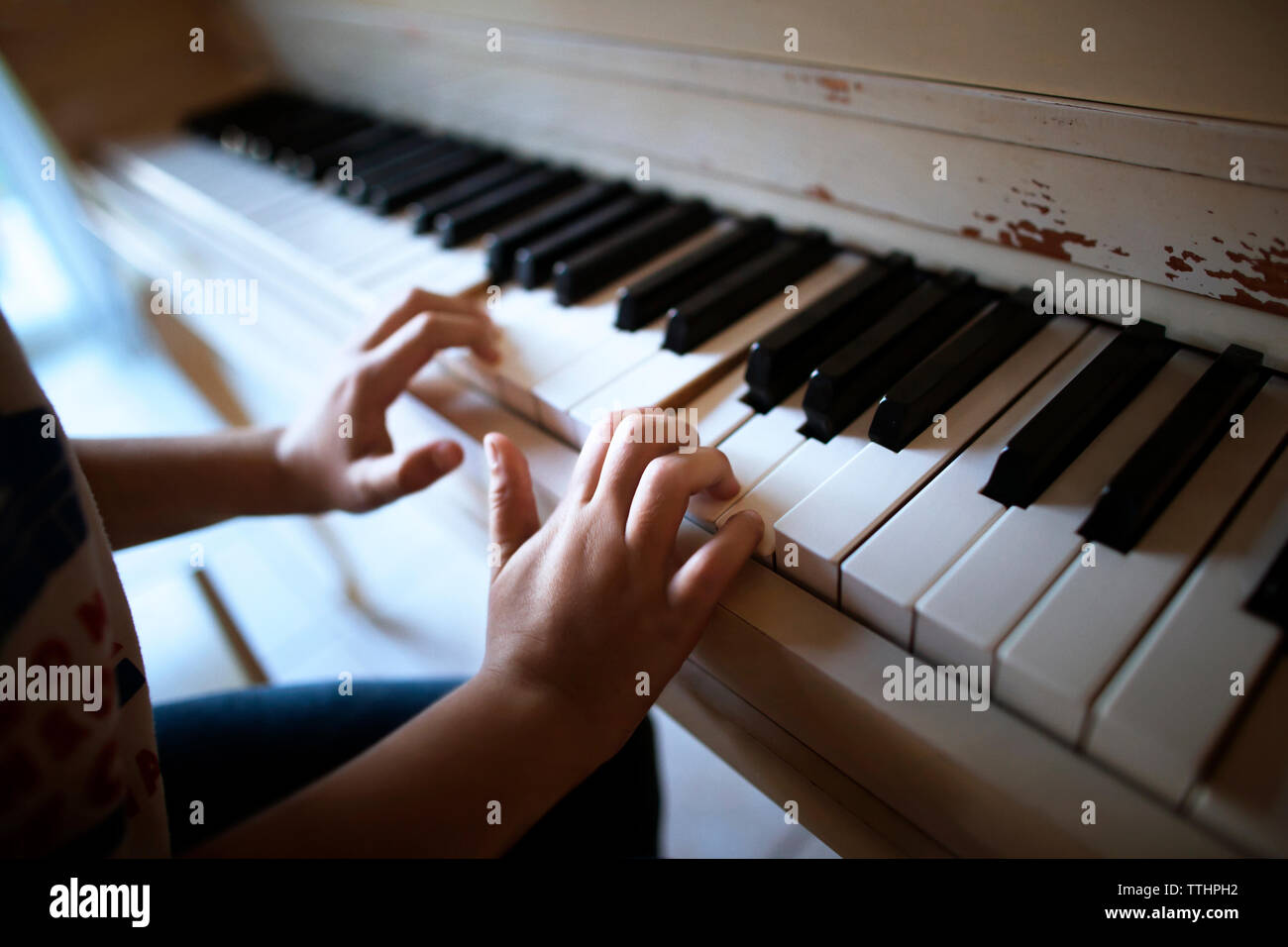 Close-up di boy suonare il pianoforte a casa Foto Stock
