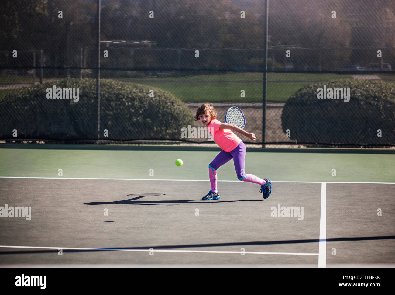 Ragazza giocando a tennis a corte Foto Stock