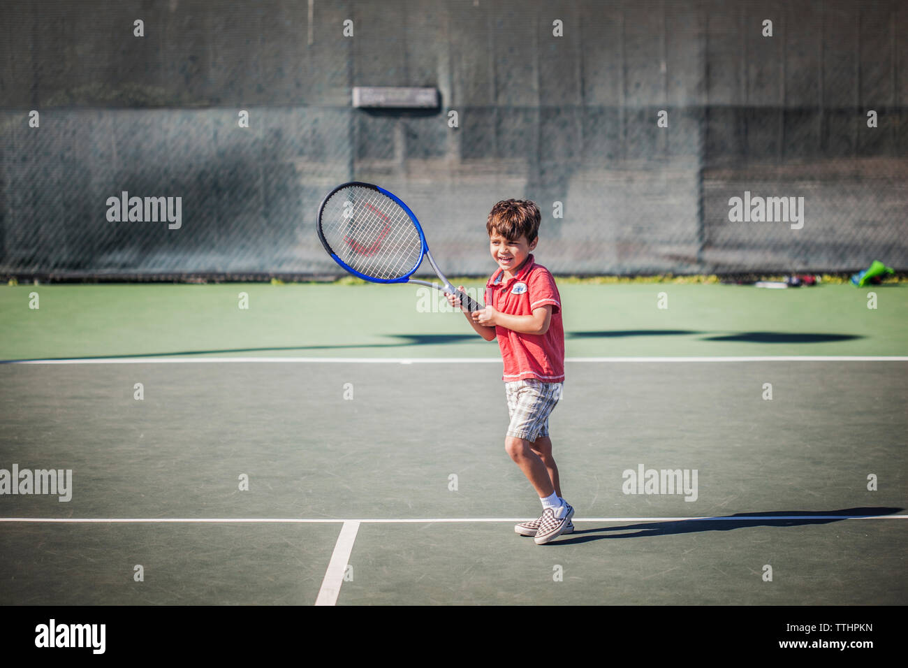 Ragazzo holding racchetta da tennis mentre in piedi a corte Foto Stock