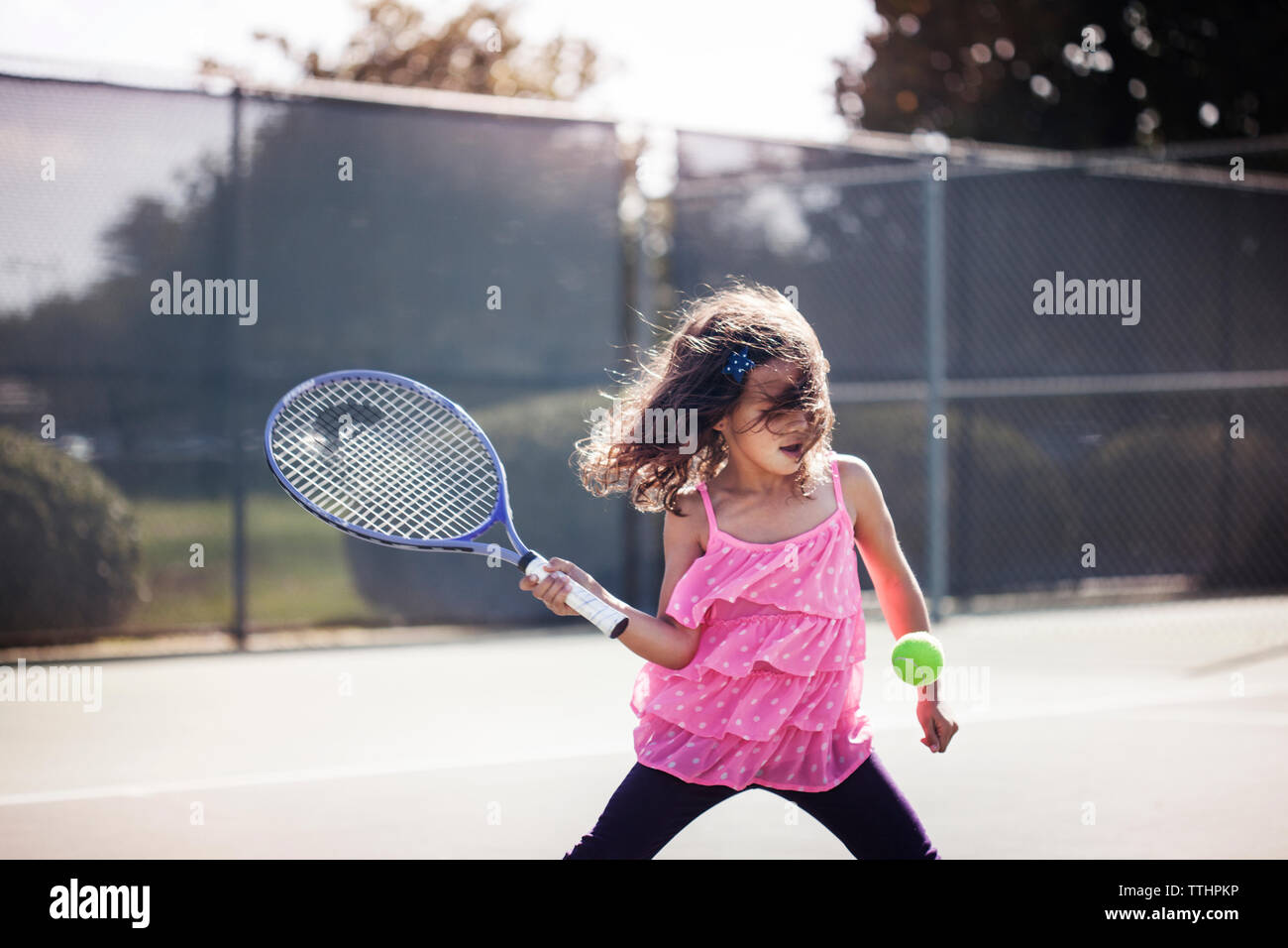 Ragazza che gioca a tennis su corte Foto Stock