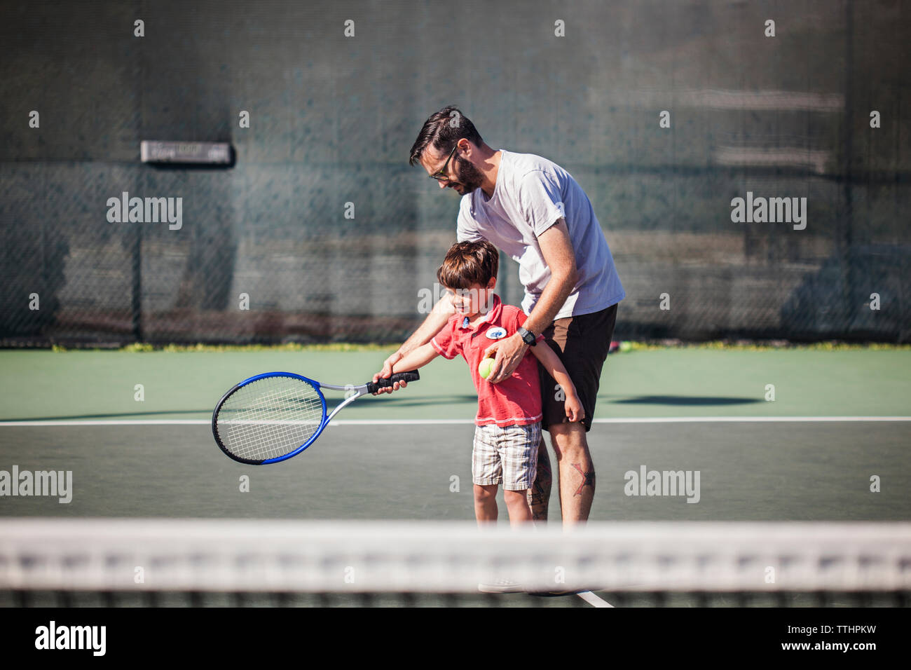Padre figlio di insegnamento tennis Foto Stock