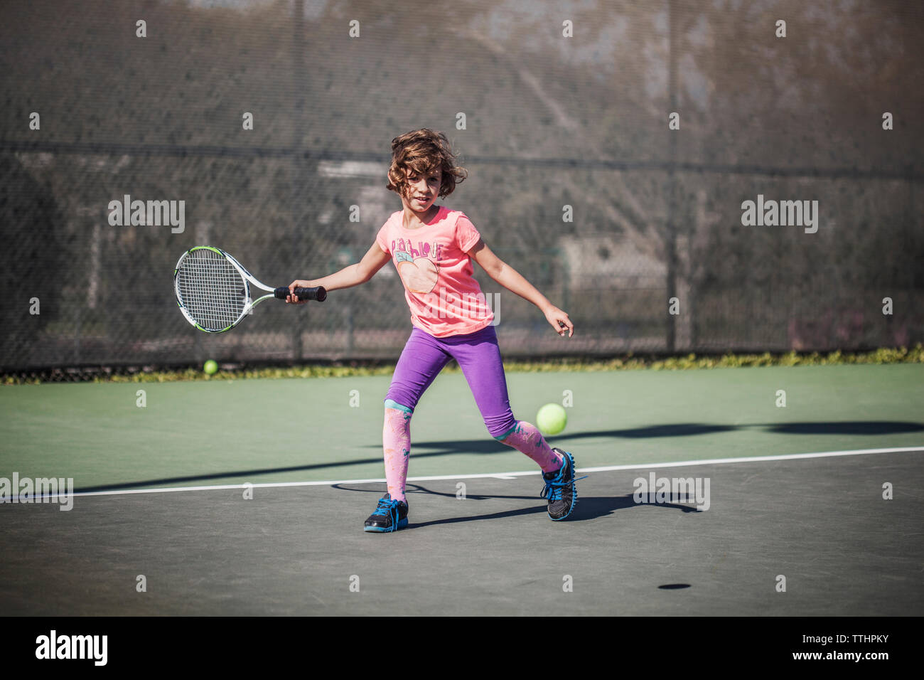 Ragazza giocando a tennis a corte Foto Stock