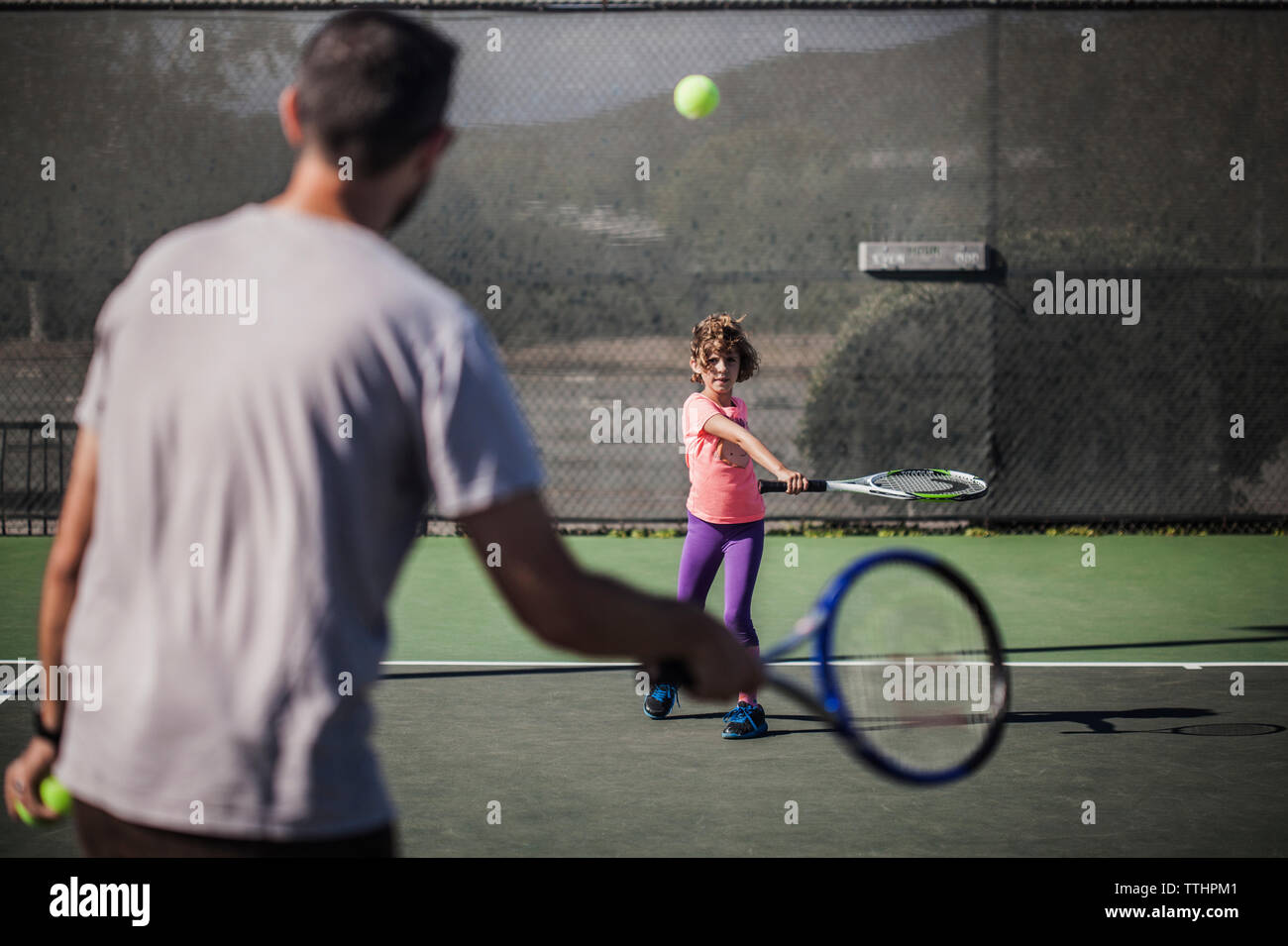 Padre e figlia giocando a tennis su corte Foto Stock