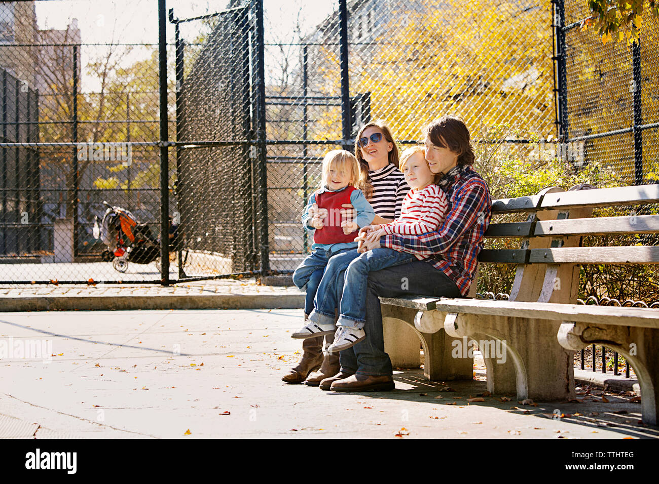 Famiglia seduta sul banco in posizione di parcheggio Foto Stock