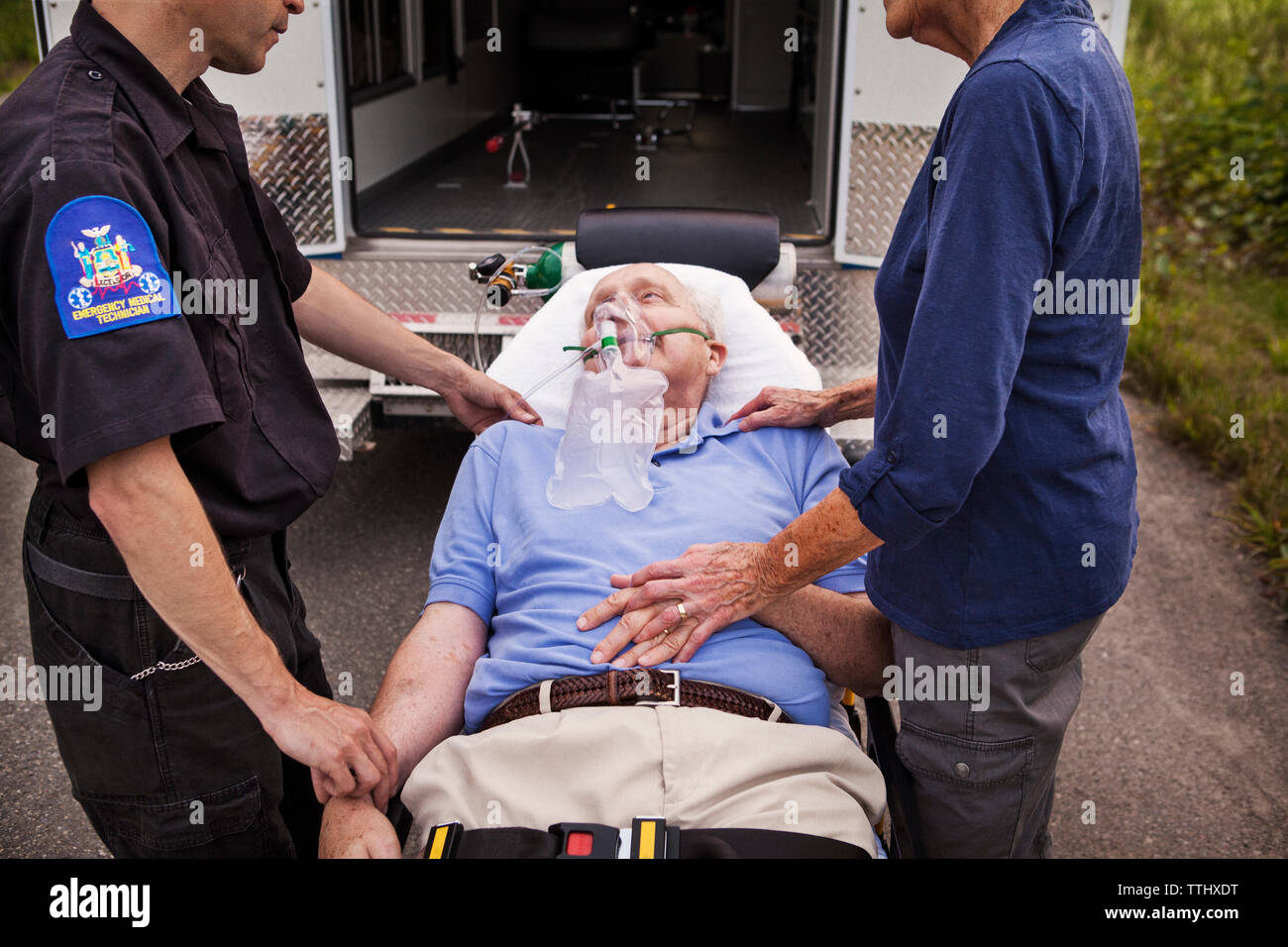 Immagine ritagliata di personale paramedico e donna in piedi dal paziente sdraiato sulla barella in ospedale Foto Stock