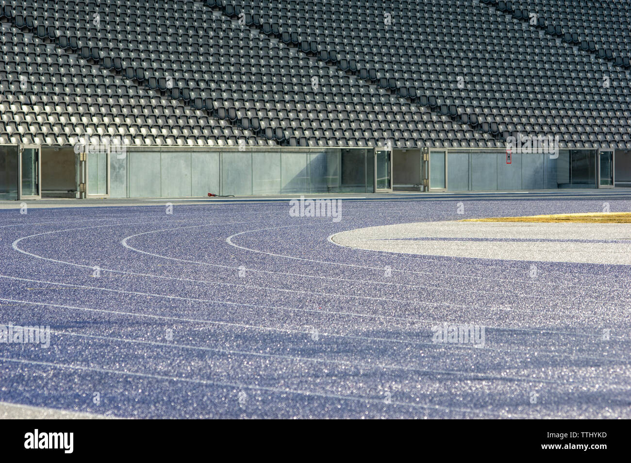 Curva con il bagnato in tartan blu acceso via in stadio olimpico di Berlino Foto Stock