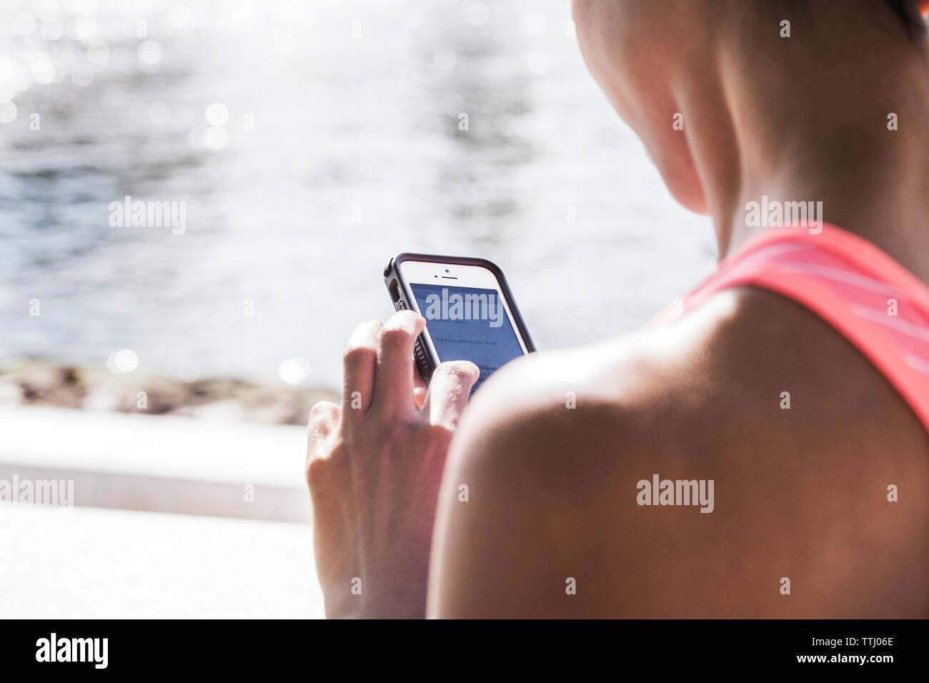 Sezione mediana della donna utilizzando il telefono cellulare at promenade Foto Stock