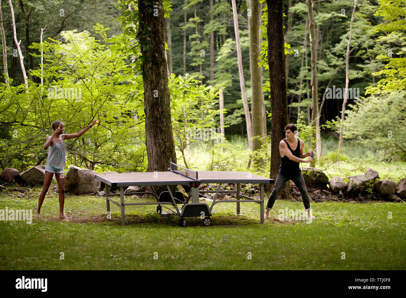 Giovane giocando a ping-pong nella foresta Foto Stock