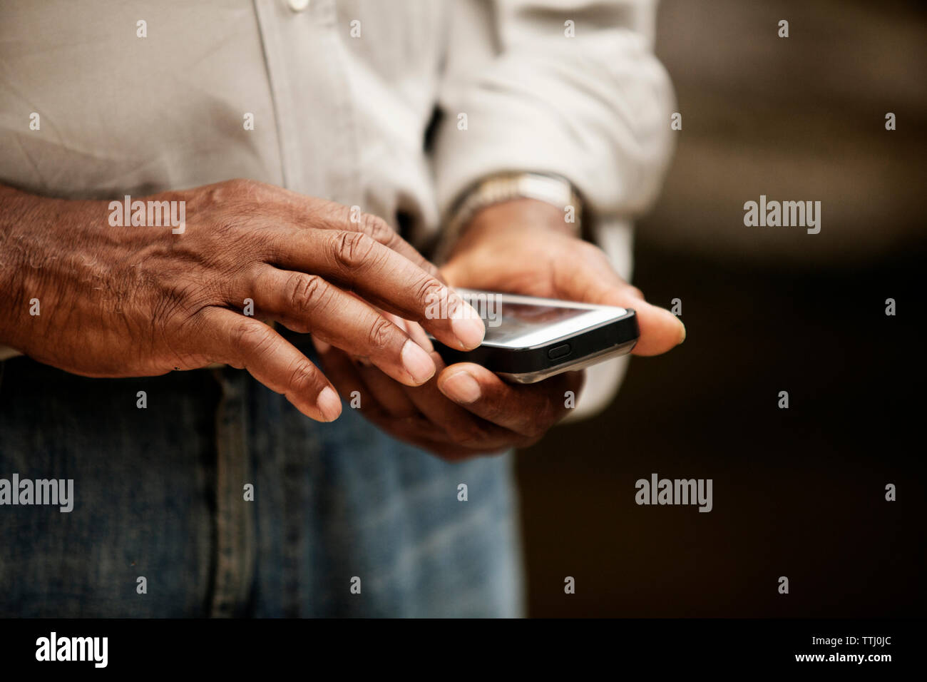 Sezione mediana dell'uomo utilizzando il telefono cellulare Foto Stock