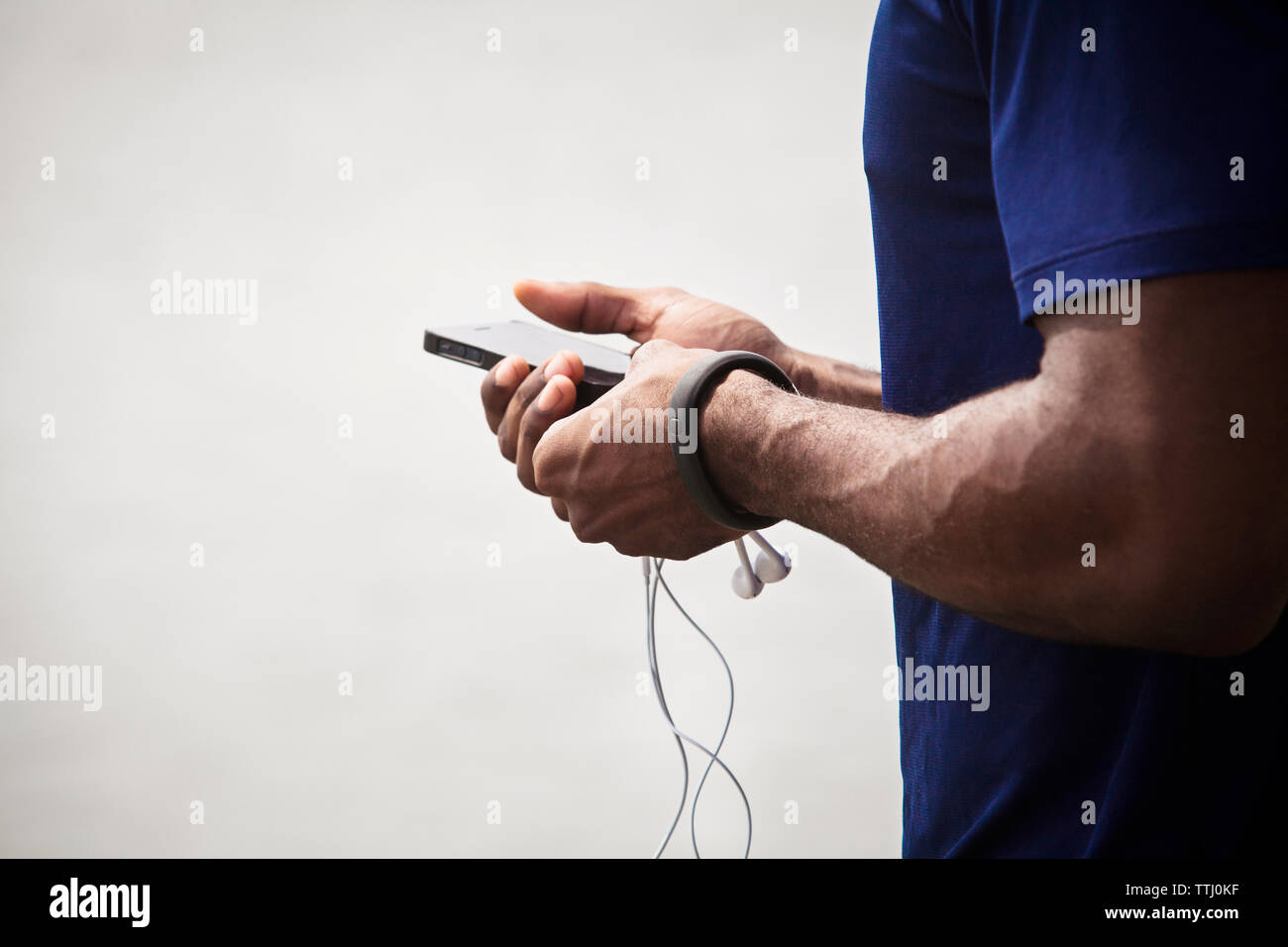 Sezione mediana dell'uomo utilizzando il telefono cellulare Foto Stock