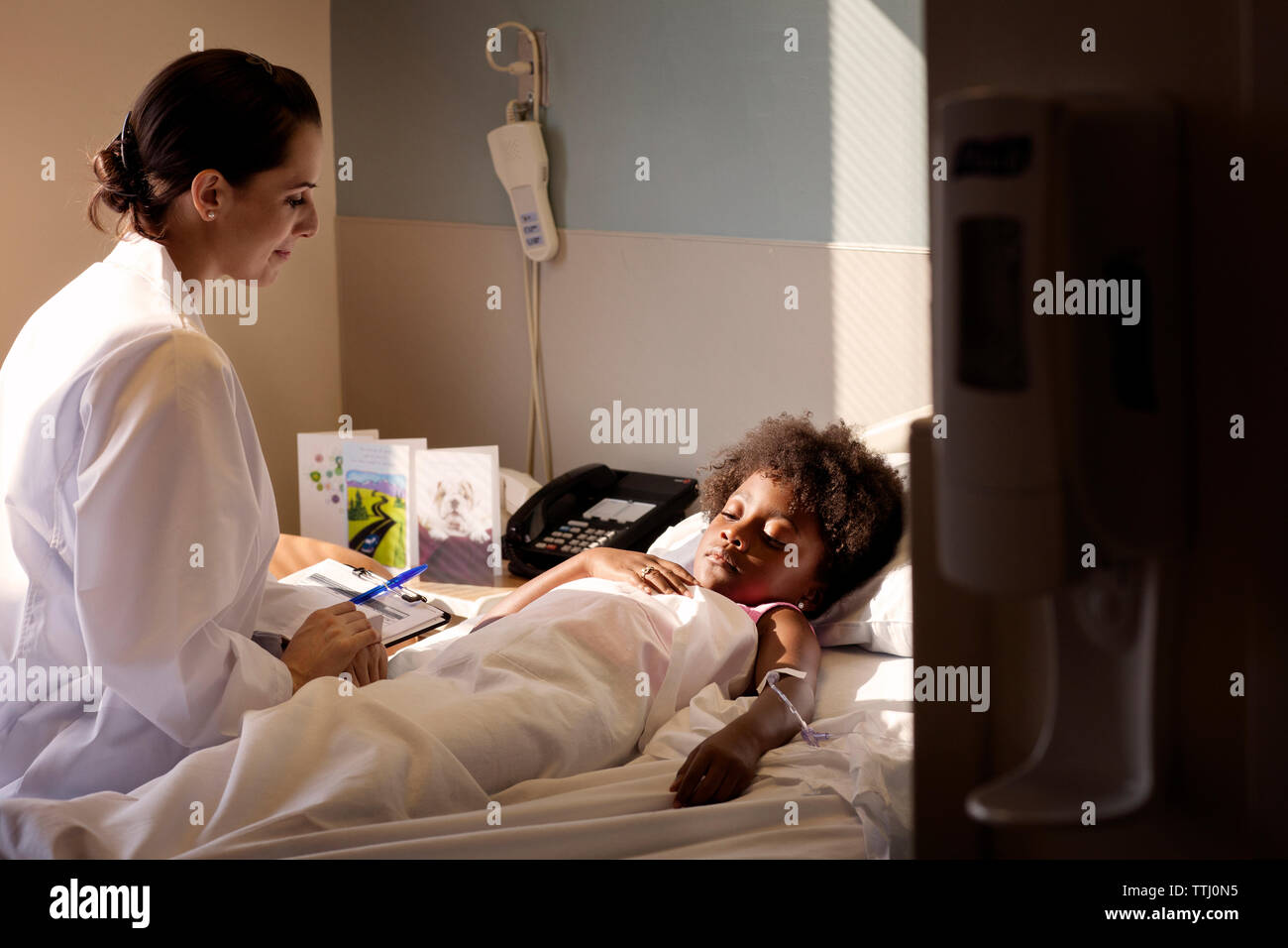 Medico guardando il paziente dorme sul letto in ospedale Foto Stock