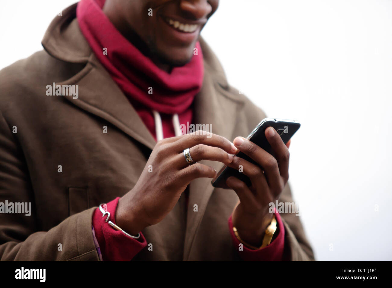 Sezione mediana di uomo sorridente con il telefono cellulare Foto Stock