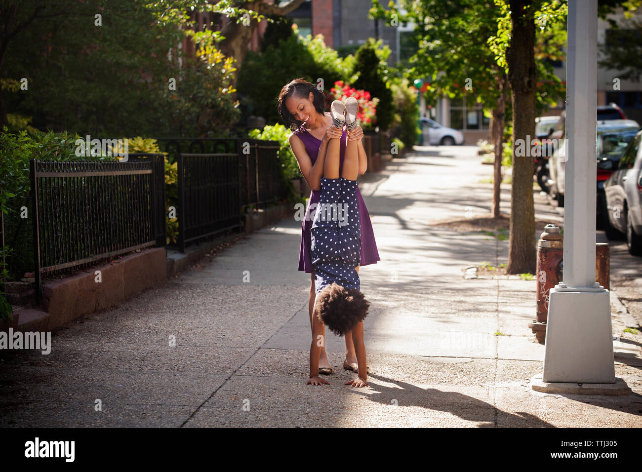 La madre ad assistere la ragazza per la pratica di supporto a mano sul sentiero Foto Stock