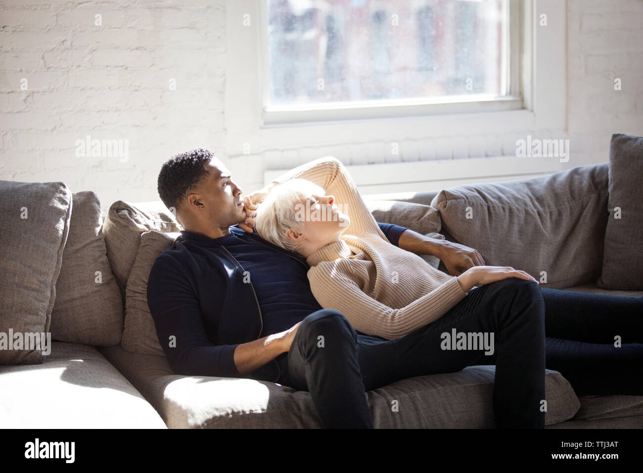 Multi-etnico giovane rilassante sul divano di casa Foto Stock