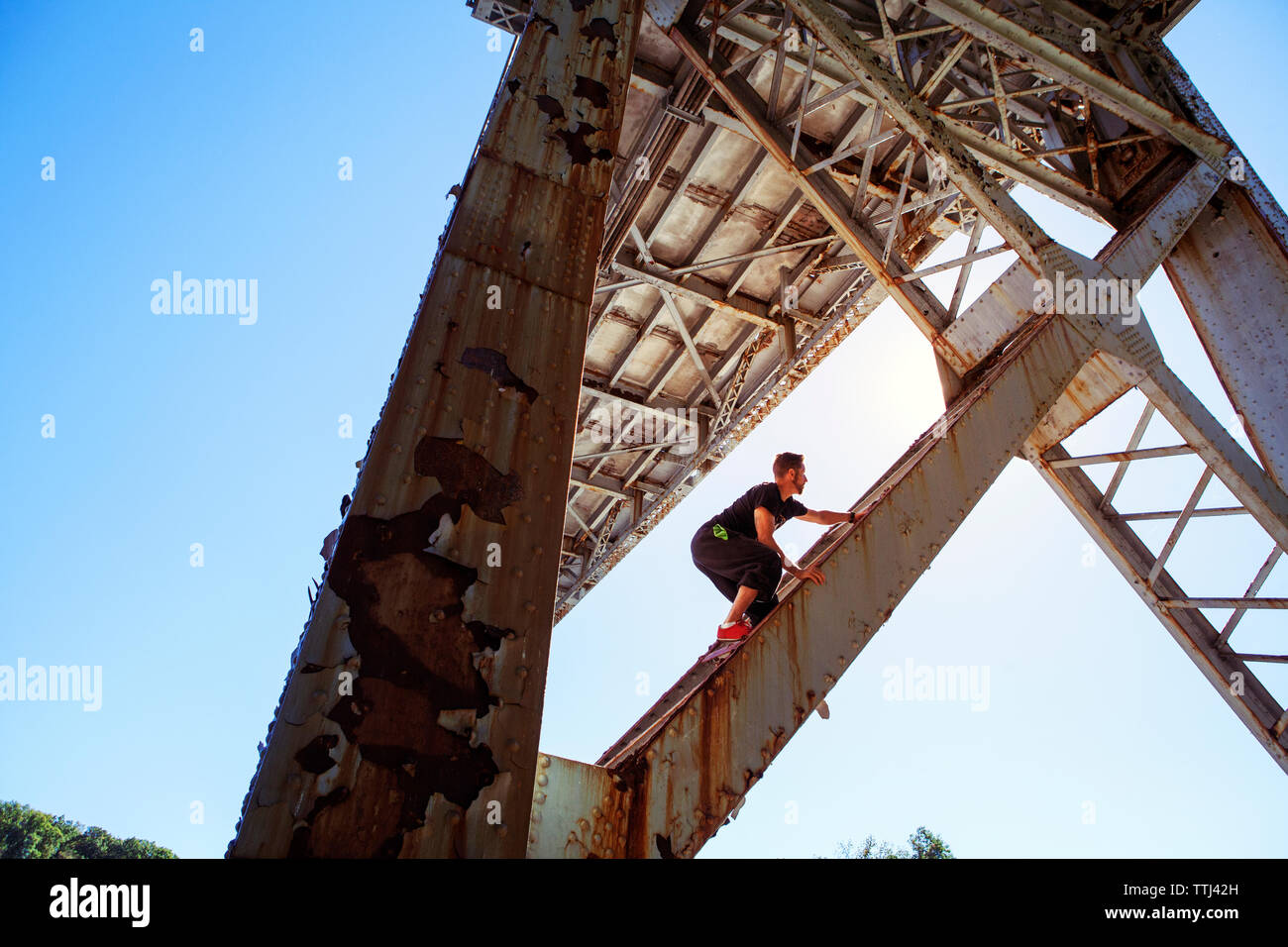 Basso angolo di visione dell'uomo ponte di arrampicata Foto Stock