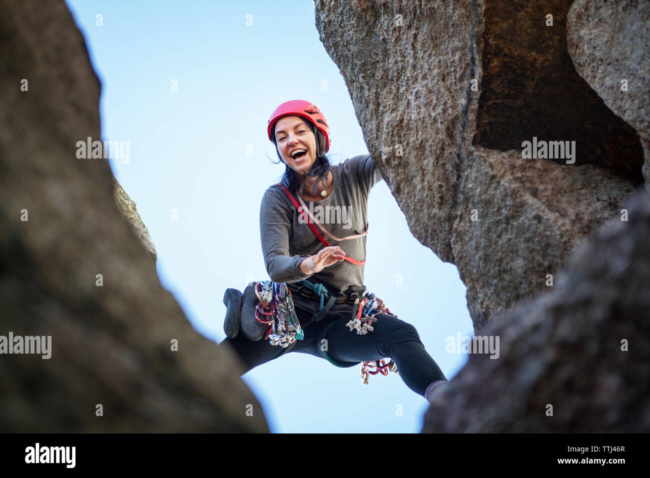 Basso angolo di visione della donna felice palestra di roccia Foto Stock